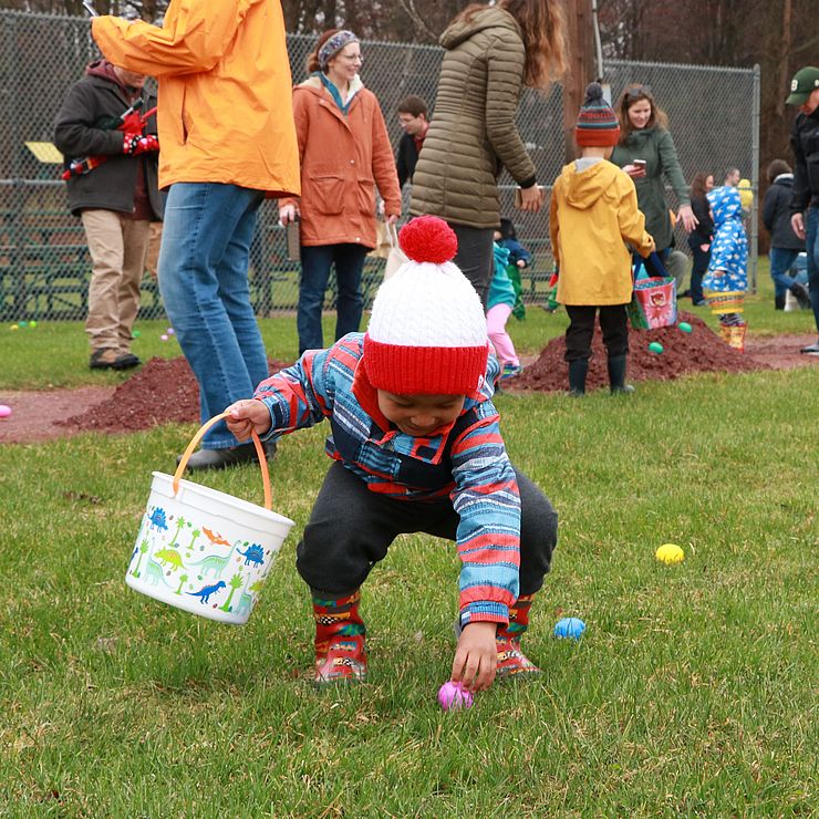 Toddler picking up easter egg